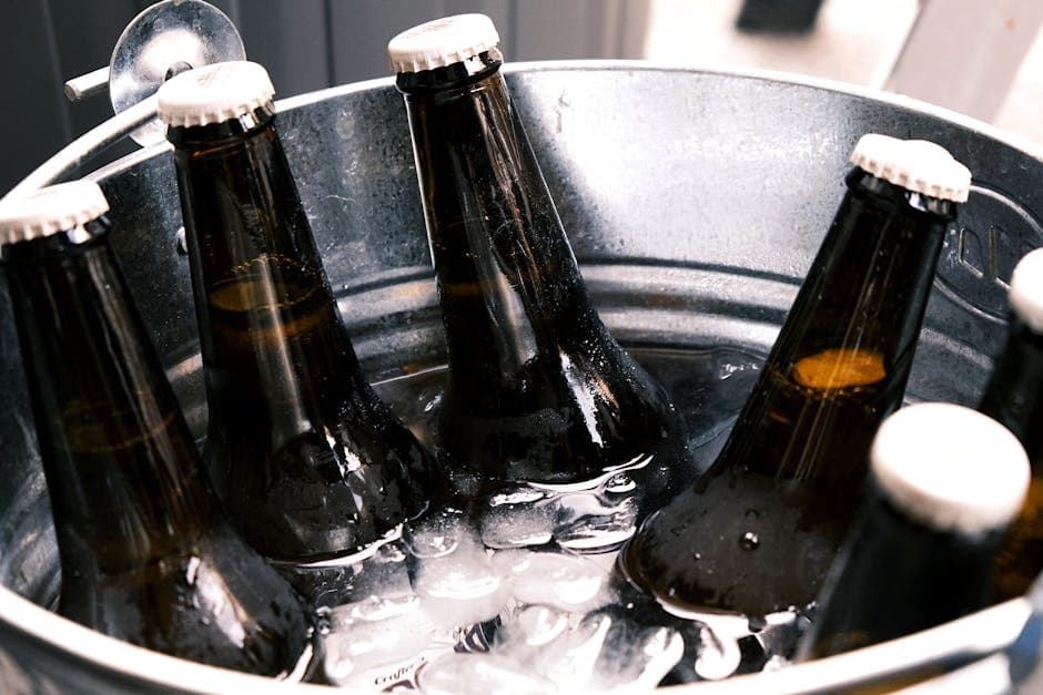 Refreshing ice-cold beer bottles in a metal bucket, perfect for party vibes.