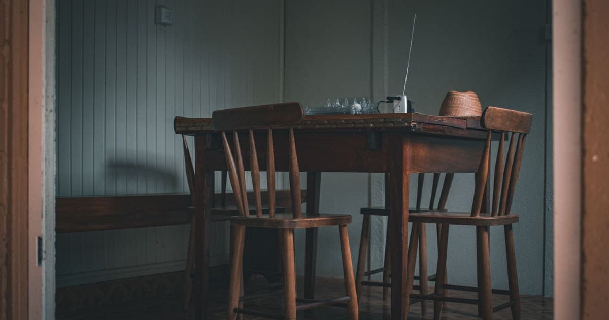 Cozy indoor scene featuring a wooden table and chairs, with a vintage radio.